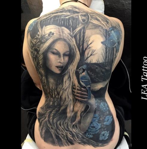A forest witch that is one with the trees . Full back piece in black & gray with color accents.